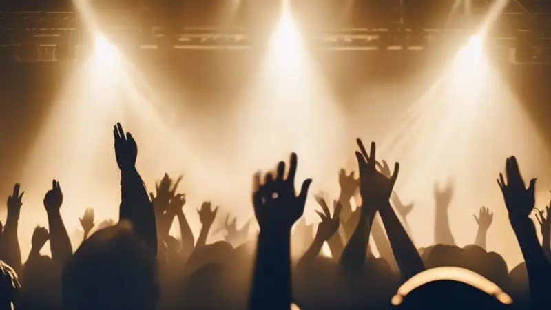 Worship with hands raised under stage light